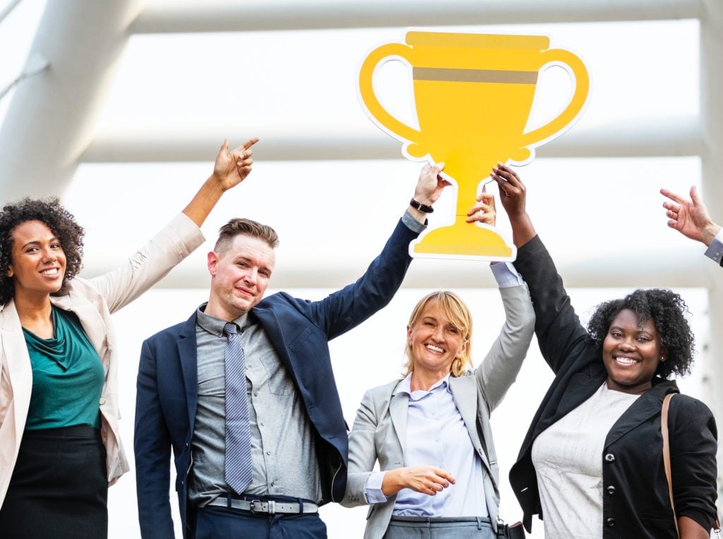 business people raising trophy, achievement, award