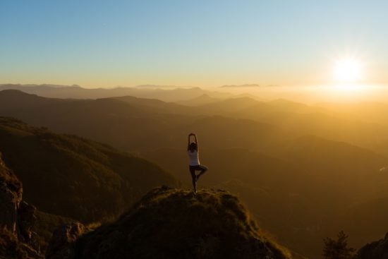 Employ a creative, holistic approach to interview preparation; woman doing yoga at sunrise.