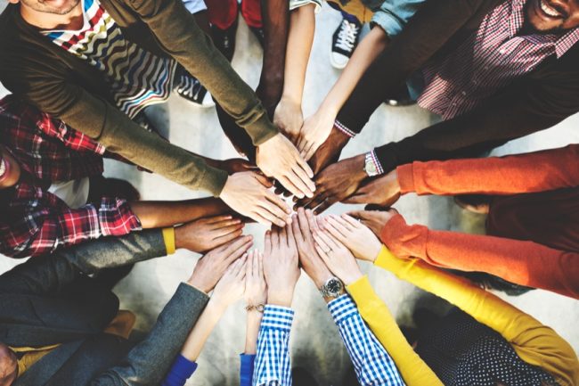 Hands held together in support, representing a community of practice